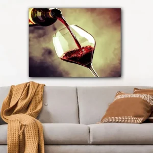 Canvastavla 70x100 cm - Vinflaska hälls i ett glas med rödvin som skapar en elegant och inbjudande atmosfär - Inredning & dekor Snabb frakt