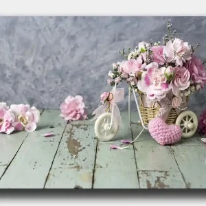 Canvastavla 70x100 cm - Vacker bukett med rosa blommor i en liten cykelkorg - Inredning & dekor Begränsat antal