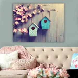 Billig Canvastavla 70x100 cm - Två fågelholkar hängande på en gren med blommor i bakgrunden - Inredning & dekor