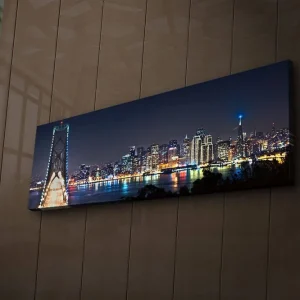 Begränsat antal Canvastavla med LED-belysning 30x90 cm - Nattlig stadsbild med en bro och silhuetter av skyskrapor Mörkblå / Ljusgrön / Vit - Inredning