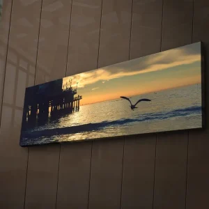 Canvastavla med LED-belysning 30x90 cm - Solnedgång över havet med en fågel i flykt Orange / Blå / Grå - Inredning Säker betalning