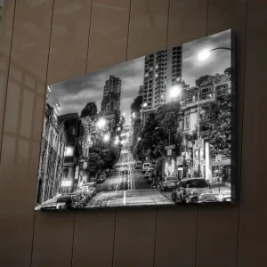 Sänkt pris Canvastavla med LED-belysning 45x70 cm - Svartvit stadsbild med en brant gata och bilar längs trottoaren Svart / Vitt / Grått - Inredning