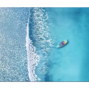 Canvastavla 70x100 cm - Ensam båt på ett klart, turkost hav med vita vågor som rullar in mot stranden - Inredning & dekor Köp online