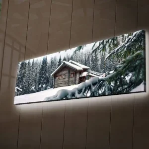 Kampanjpris Canvastavla med LED-belysning 30x90 cm - Vinterlandskap med en stuga omgiven av snö och granar Vit / Grön / Brun - Inredning