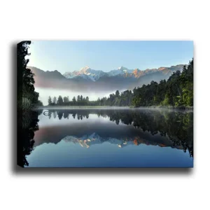 Canvastavla 70x100 cm - Spegelbild av majestätiska berg som reflekteras i en stilla sjö omgiven av grönskande skog - Inredning & dekor Sänkt pris
