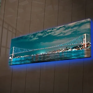 Beställ idag Canvastavla med LED-belysning 30x90 cm - Bro över en stilla vattenyta med stadsljus i bakgrunden Mörkblå / Turkos / Ljusgrön - Inredning